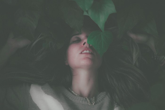 Woman with leaves over her face