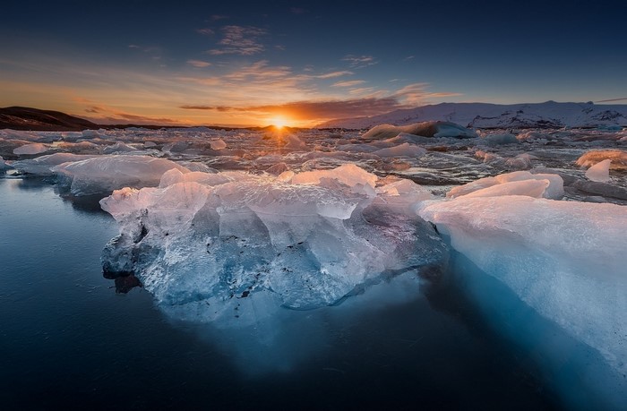 Icebergs floating in water at sunset