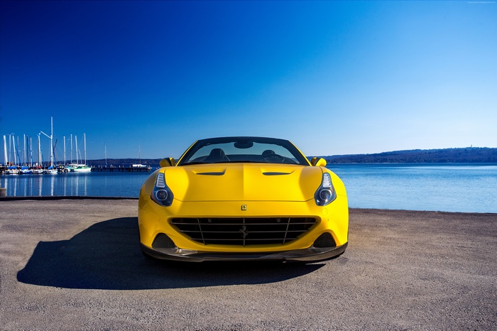 Yellow Ferrari California T convertible by a lake