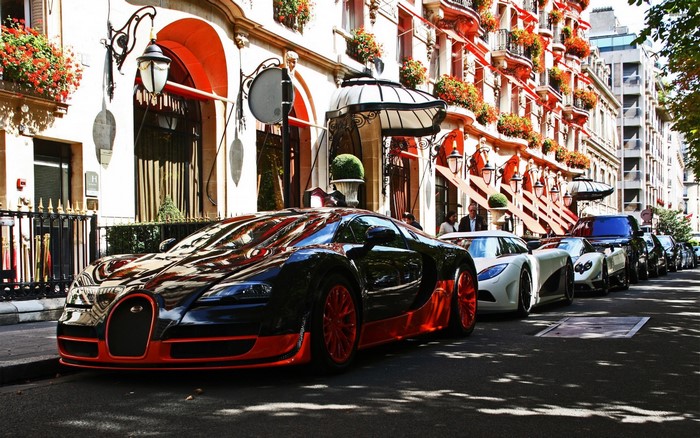 Bugatti Veyron and other supercars parked in front of a building