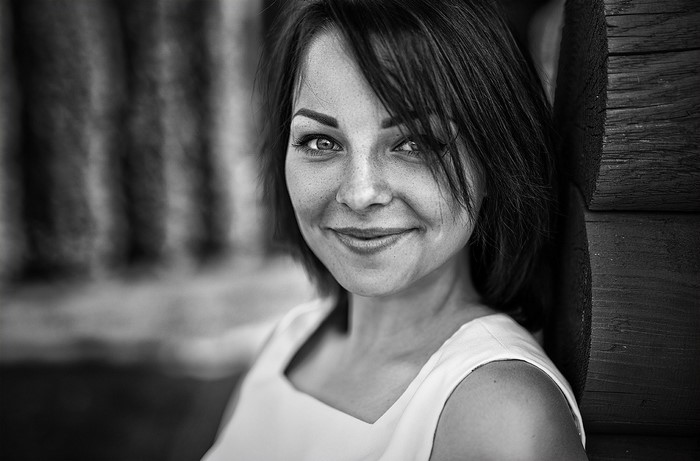 Monochrome portrait of a smiling woman with freckles