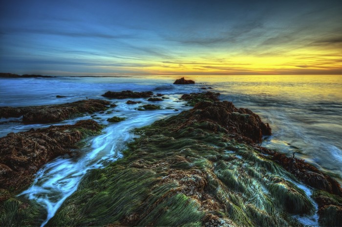 Sunset over rocky shore with ocean waves