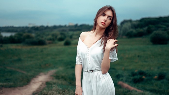 Woman in white dress posing outdoors