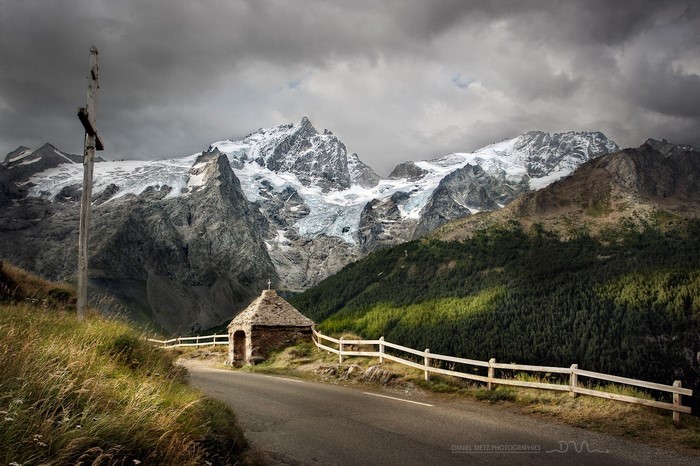 Mountain pass with chapel and snow-capped Alps