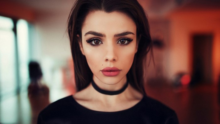 Woman with dark hair and choker necklace