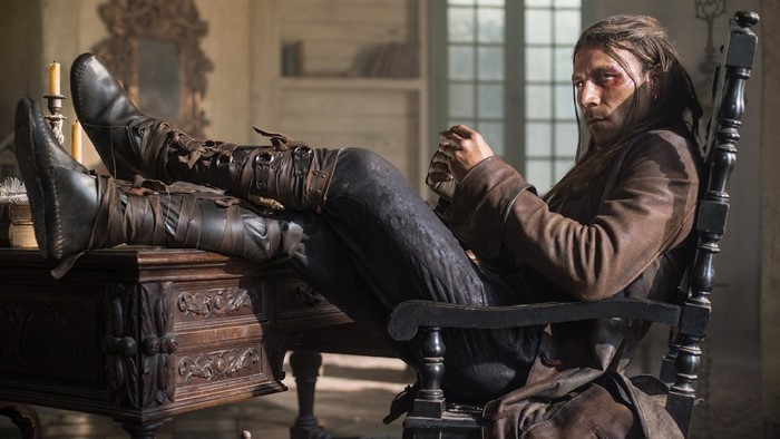 Man with bruised face sitting in a chair in Black Sails