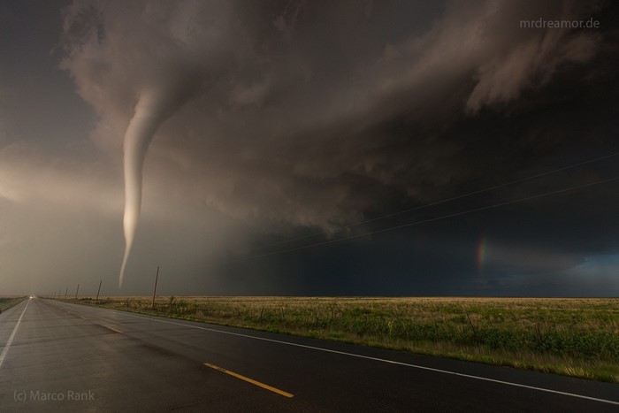Tornado over a wet road in a stormy landscape