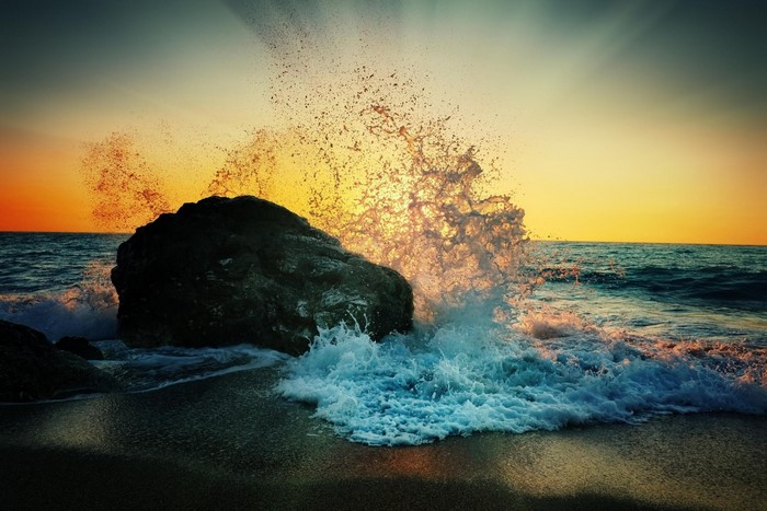 Sunset Waves Crashing Against Rocky Shore