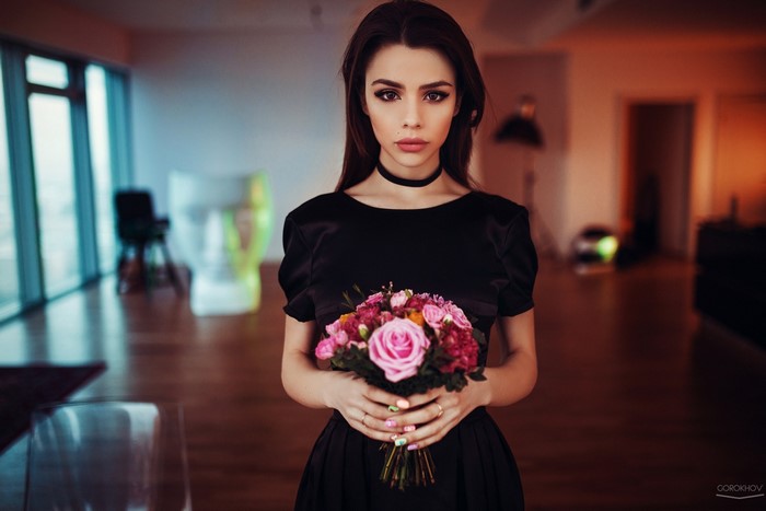 Woman in black dress holding a bouquet of flowers