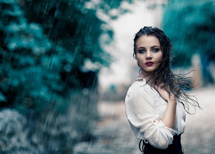 Woman in white shirt standing in the rain