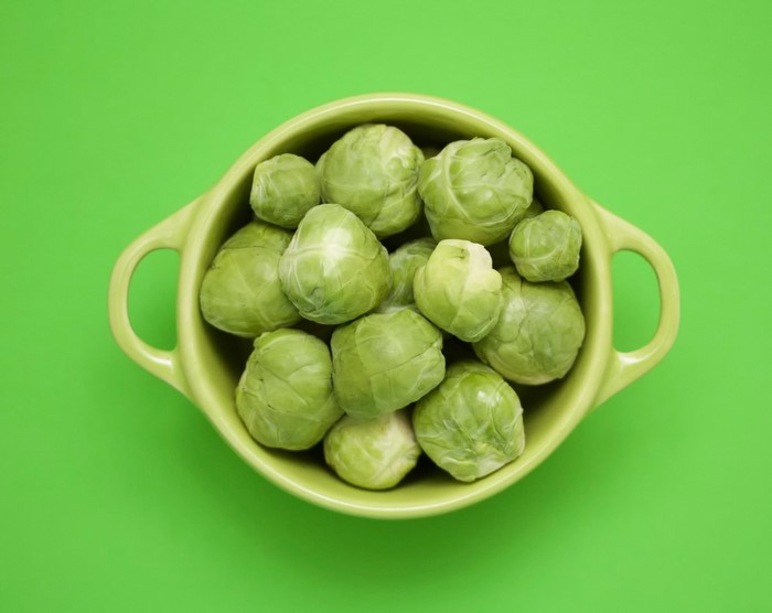 Bowl of Brussels sprouts on a green background