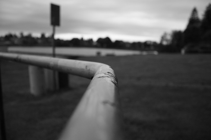 Monochrome photography of a metal railing outdoors