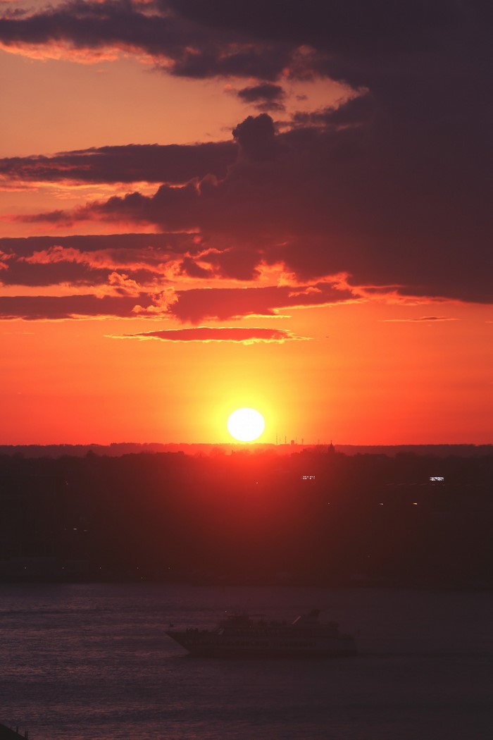Sunset over the ocean with a boat