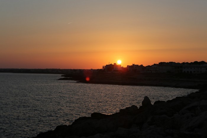 Sunset over the sea with a coastal town