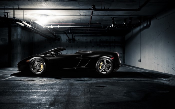 Black Lamborghini Gallardo convertible in a dark garage