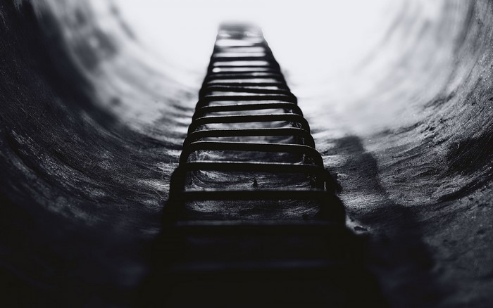 Ladder in a dark, curved tunnel