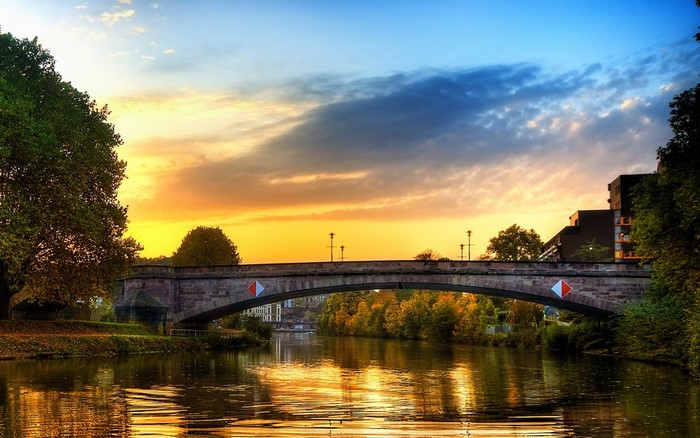 Bridge over river at sunset with autumn trees