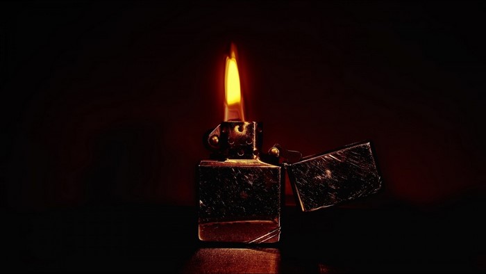 Close-up of a lit Zippo lighter in darkness