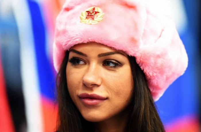 Woman wearing a pink ushanka hat with a Soviet emblem