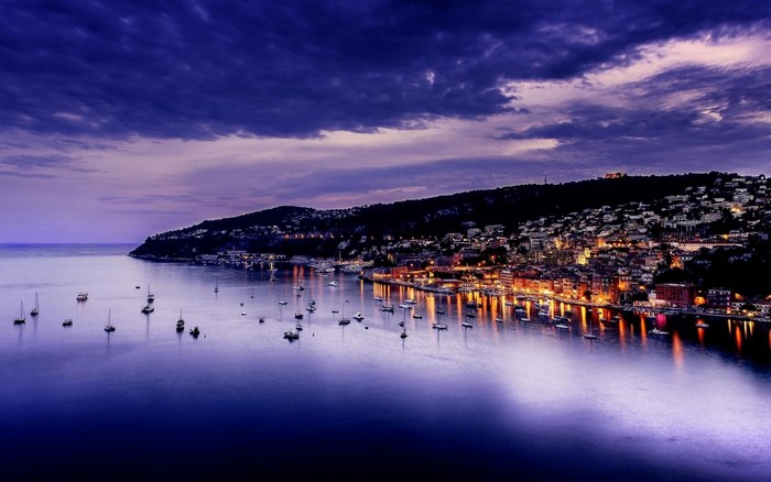 Cityscape with boats on the water at dusk