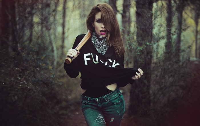 Woman with baseball bat in forest