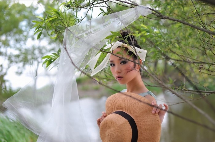 Woman with hat and veil in nature