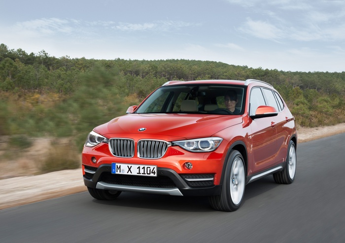 Orange BMW X1 sDrive xDrive driving on road