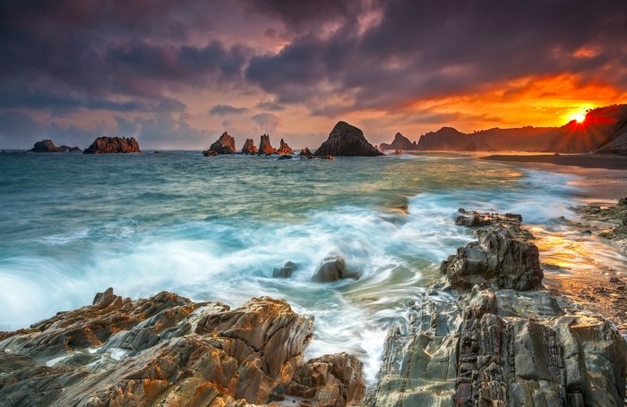 Sunset Over Rocky Seashore and Waves