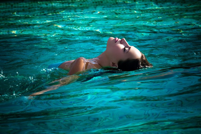 Woman floating in a swimming pool