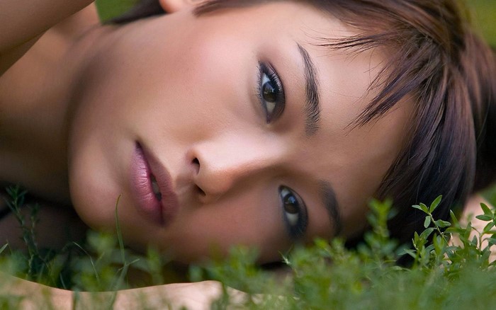 Close-Up Portrait of Woman Lying on Grass