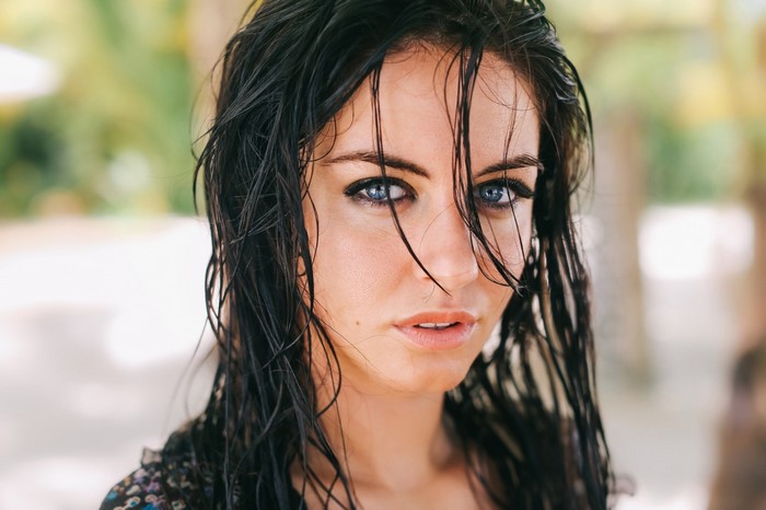 Woman with wet black hair and blue eyes