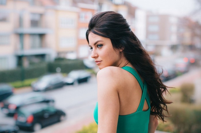 Woman with long dark hair and blue eyes in a green dress