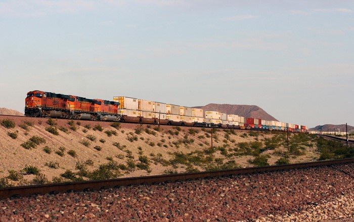 Freight train with containers in a desert landscape