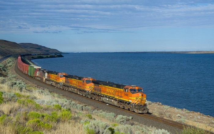 BNSF freight train on tracks by a large body of water