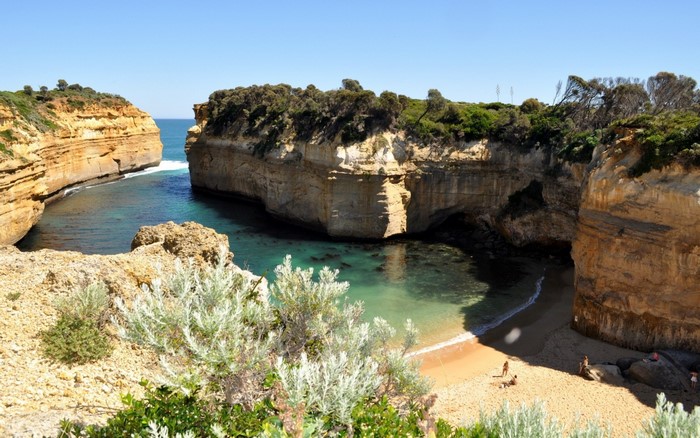 Coastal cliffs and a secluded beach cove with turquoise water