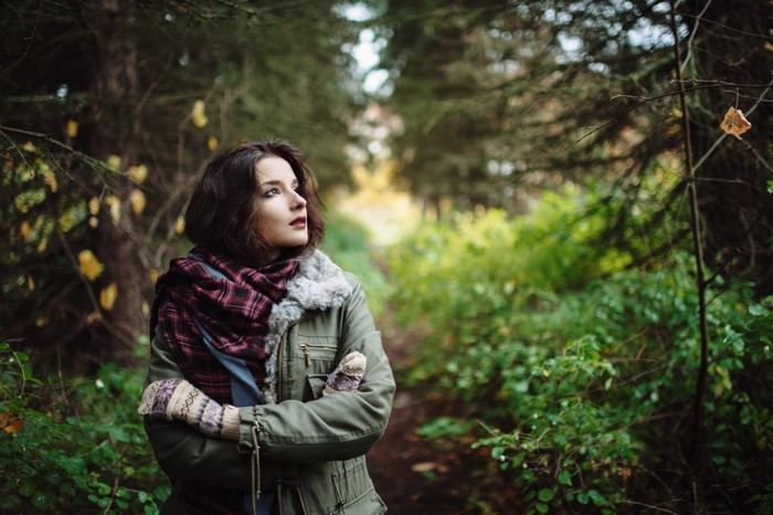 Woman in scarf and gloves in a forest