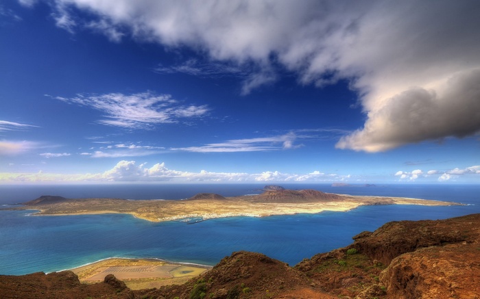Island landscape with blue ocean and dramatic clouds