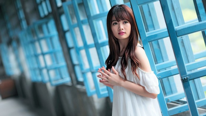 Asian woman with long brown hair in white dress
