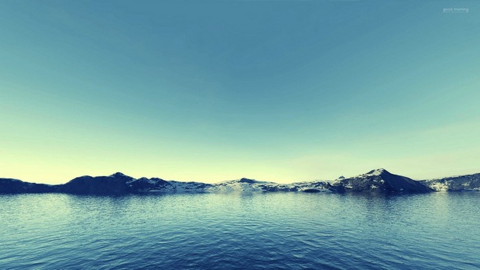 Mountains reflected in the sea under a clear sky