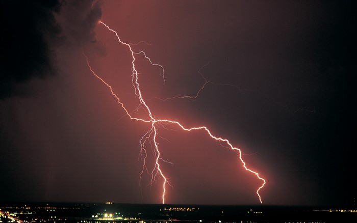 Lightning strike over a city at night