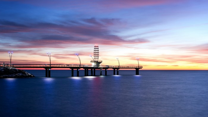 Pier with tower at sunset over the ocean