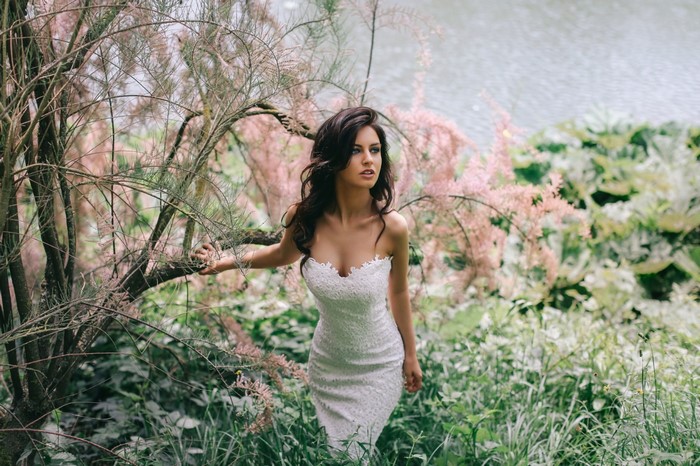 Woman in White Dress Among Spring Garden Blossoms