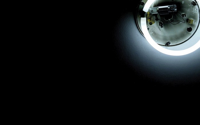 Circular fluorescent light fixture on a dark wall
