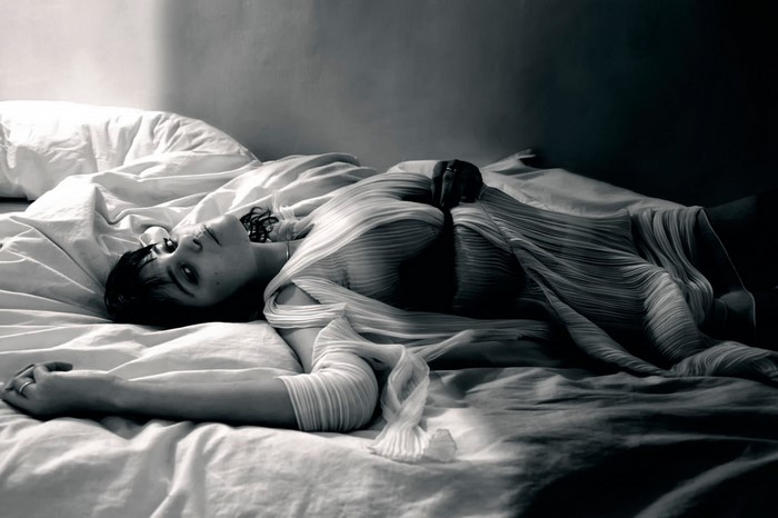 Woman lying on a bed in monochrome photography