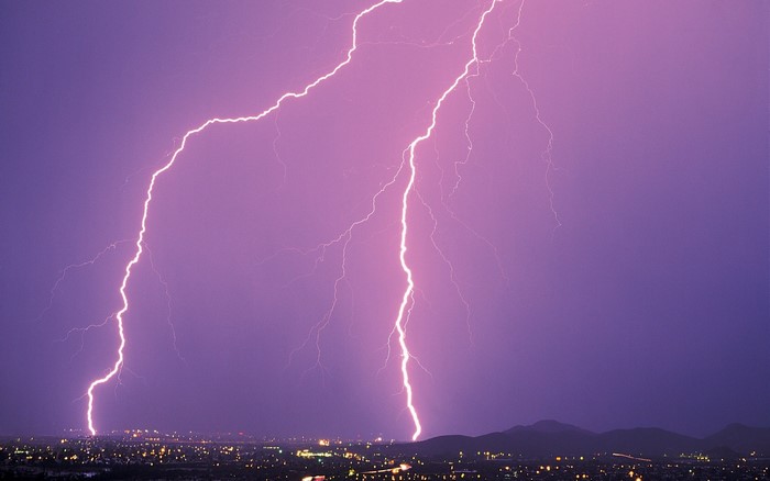 Lightning strikes over a city at night