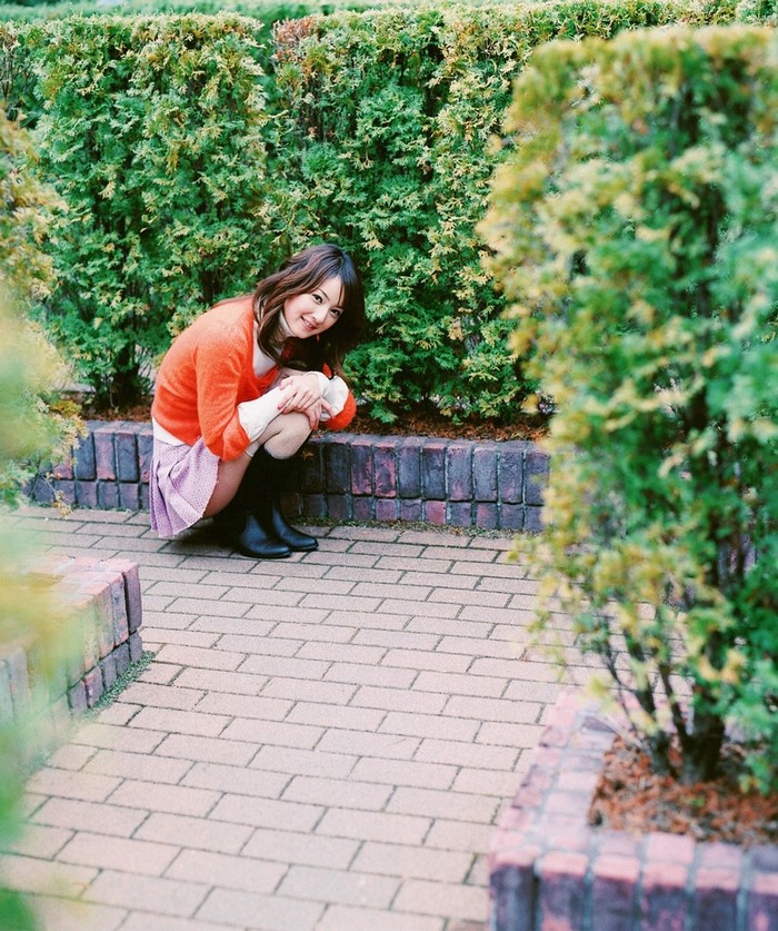 Sasaki Nozomi squatting in a garden
