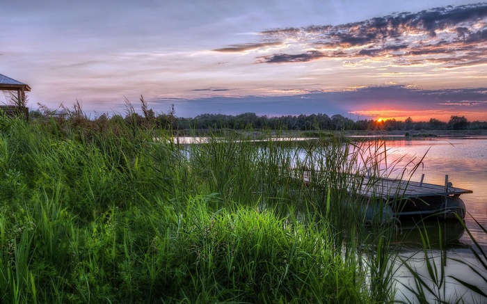 Sunset over a calm lake with a wooden dock