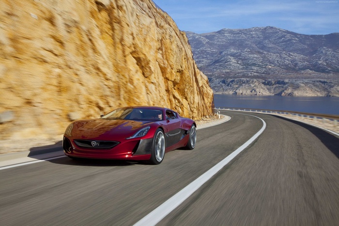Red Rimac Concept One electric hypercar on a coastal road