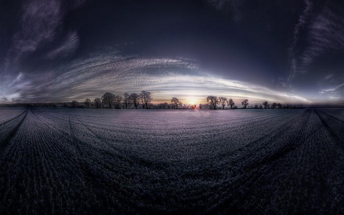 Panoramic field at sunset with dramatic clouds