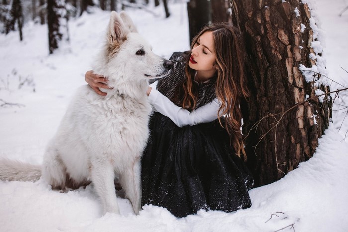 Woman and German Shepherd in a Snowy Forest